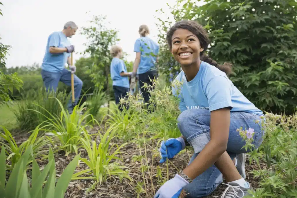 Groupe de 4 personnes dont une femme au premier plan travaillant dans la nature sur un projet eco-responsable